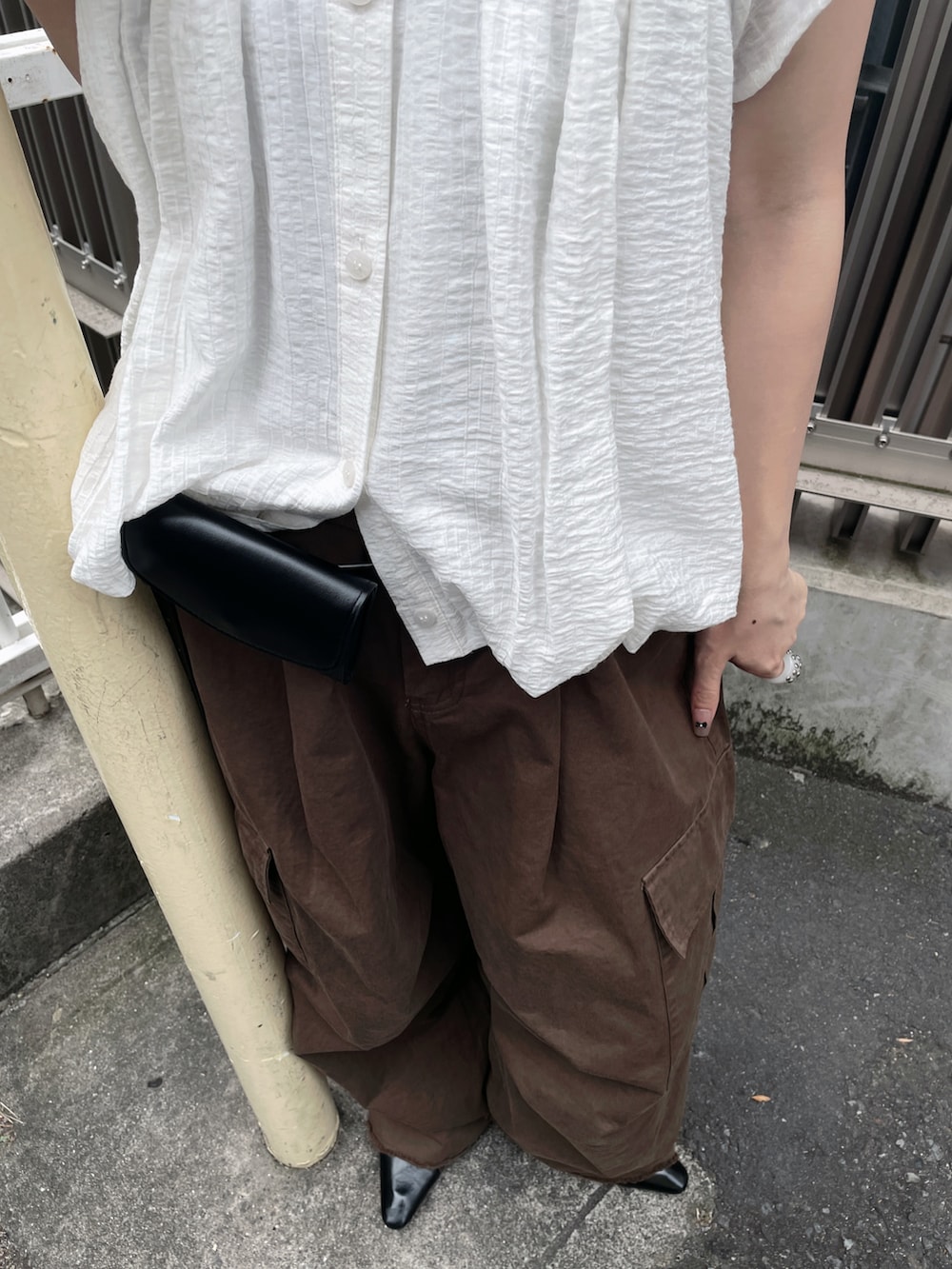ホワイト系のシャツ/ブラウス、ブラウン系のその他パンツ、ブラック系のベルトを着用したレディースの夏コーディネートの2枚目の写真