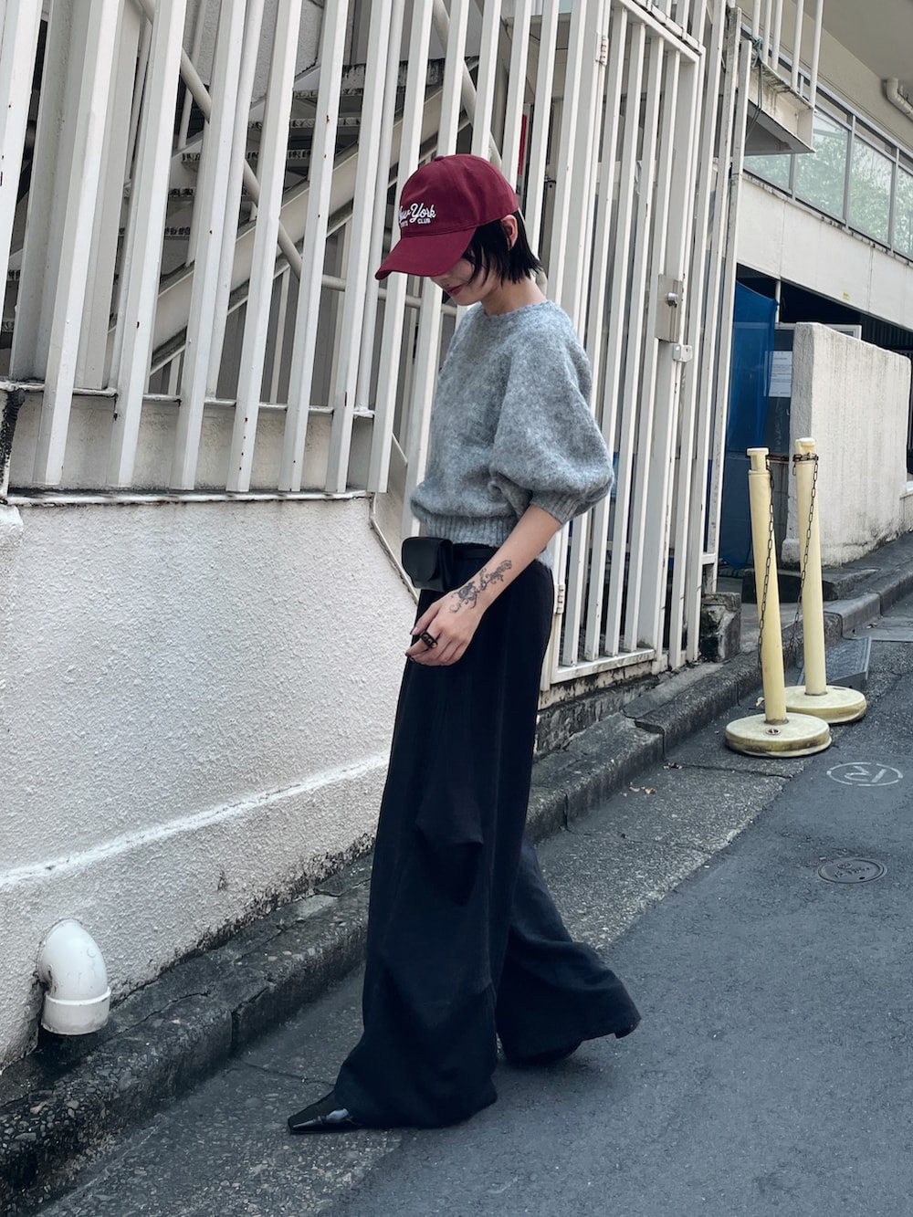グレー系のニット/セーター、ブラック系のその他パンツ、ブラック系のベルトを着用したレディースの夏コーディネートの4枚目の写真