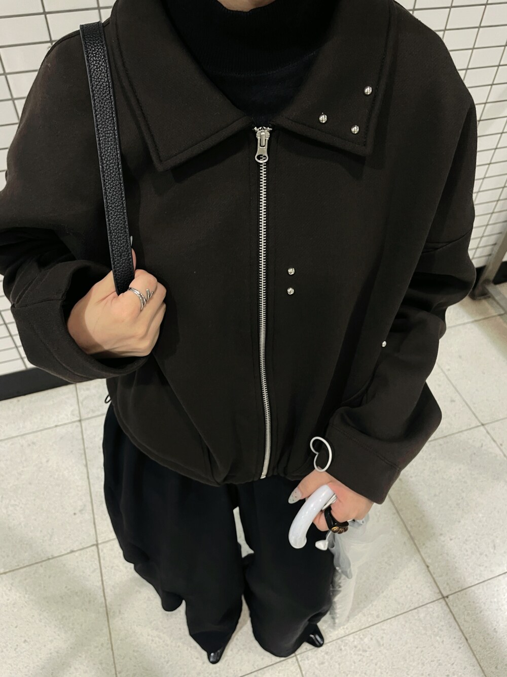 ブラウン系のブルゾン、ブラック系のその他パンツ、ブルー系のマフラーを着用したレディースの秋コーディネートの3枚目の写真