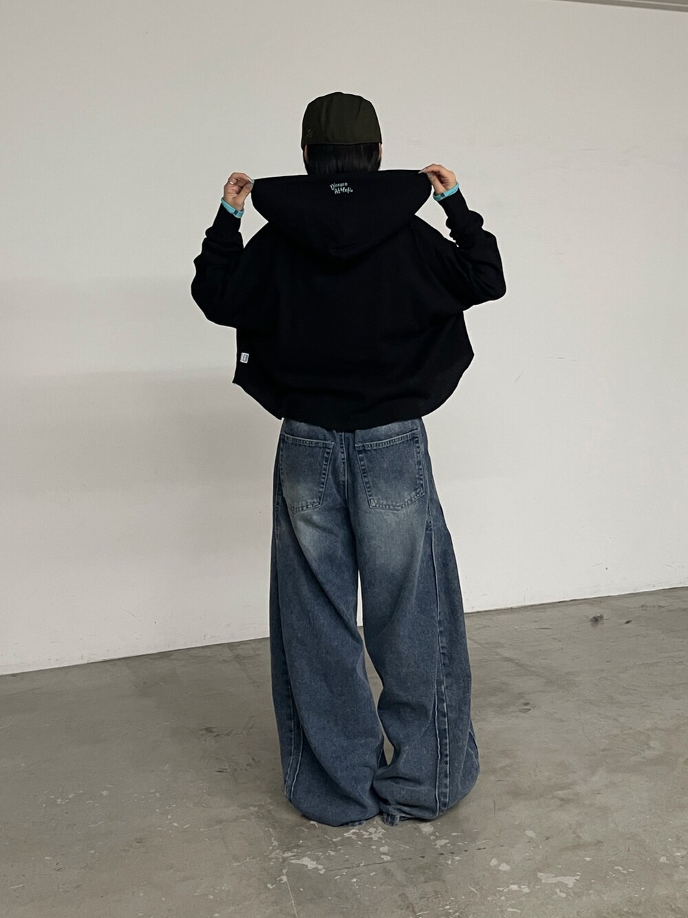 ブラック系のTシャツ/カットソー、ブルー系のデニムパンツを着用したレディースの秋コーディネートの2枚目の写真