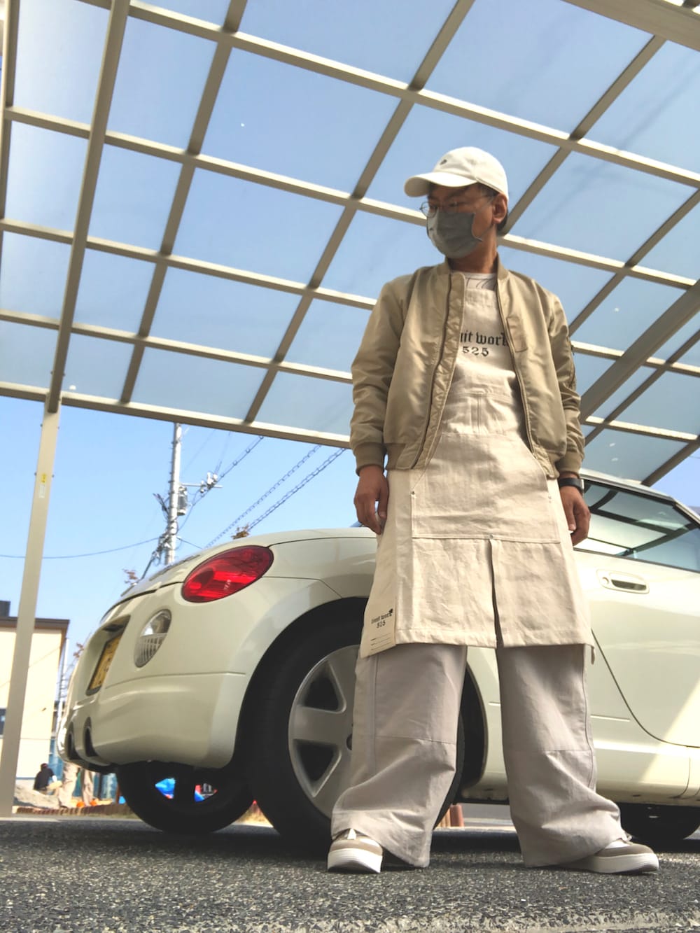 ベージュ系のTシャツ/カットソー、ホワイト系のパンツ、ベージュ系のトップスを着用したメンズの春コーディネートの2枚目の写真