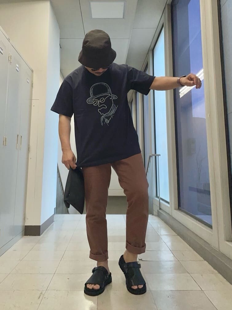 ブラック系のクラッチバッグ、ブルー系のTシャツ/カットソーを着用したメンズの春コーディネートの6枚目の写真