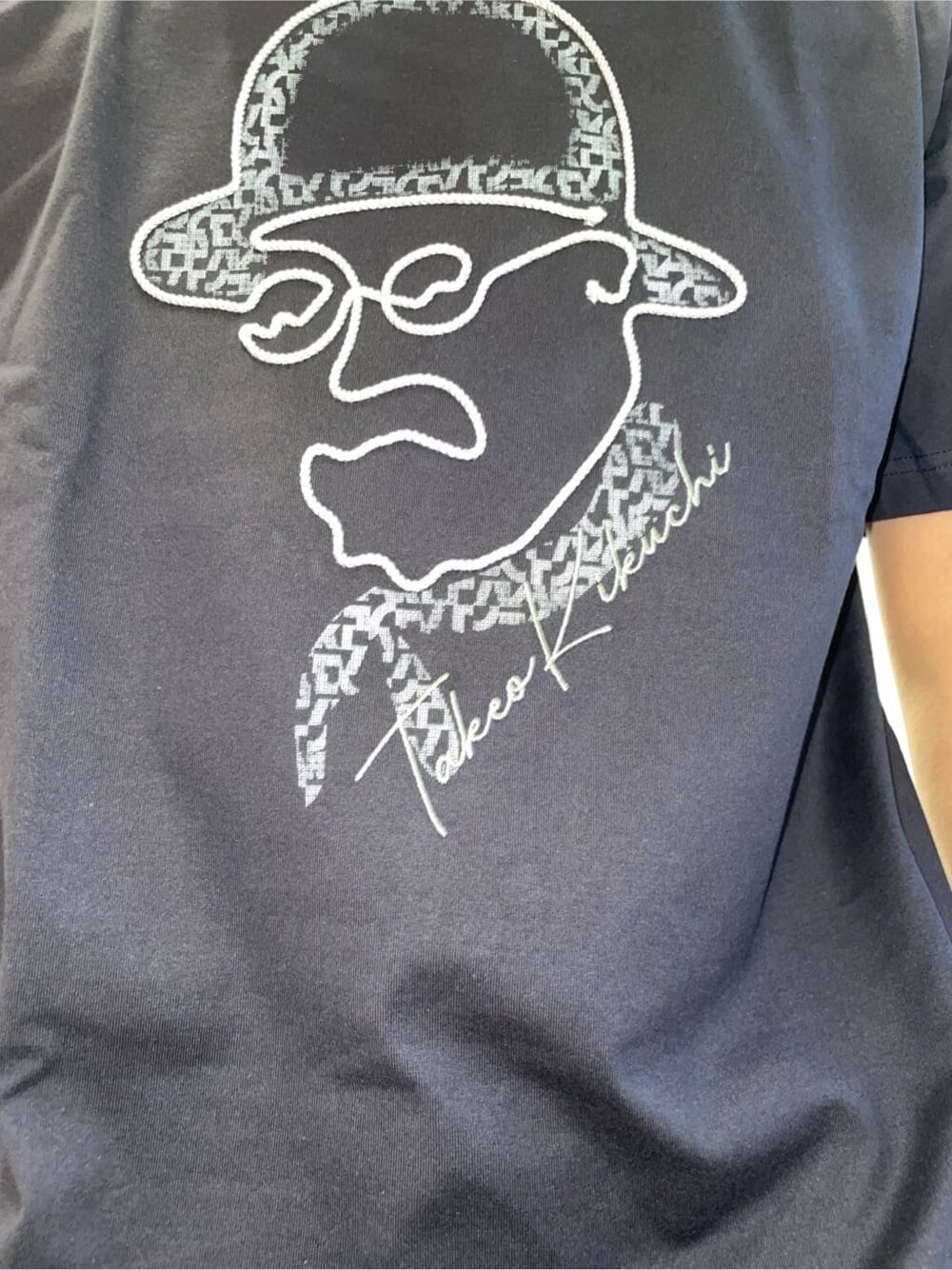 ブラック系のクラッチバッグ、ブルー系のTシャツ/カットソーを着用したメンズの春コーディネートの4枚目の写真