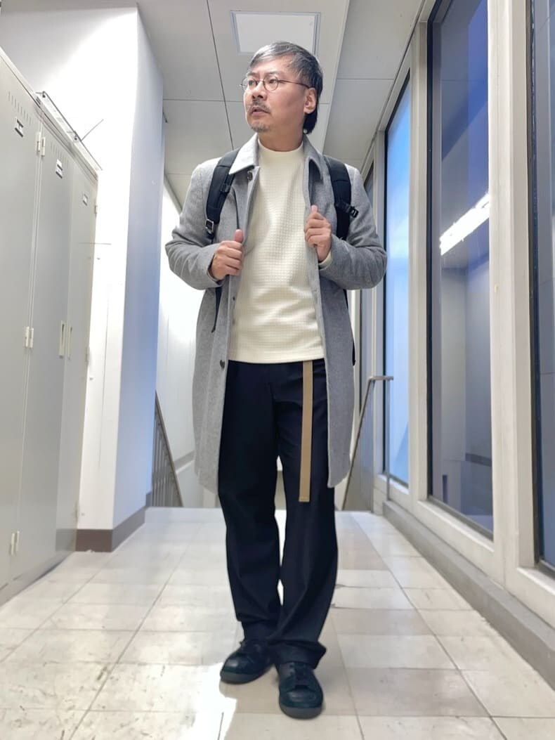 グレー系のステンカラーコート、ホワイト系のTシャツ/カットソー、ブラック系のバックパック/リュックを着用したメンズの秋コーディネートの7枚目の写真