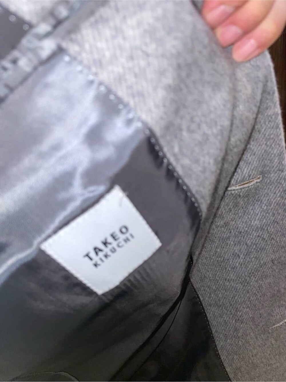 グレー系のステンカラーコート、ホワイト系のTシャツ/カットソー、ブラック系のバックパック/リュックを着用したメンズの秋コーディネートの9枚目の写真