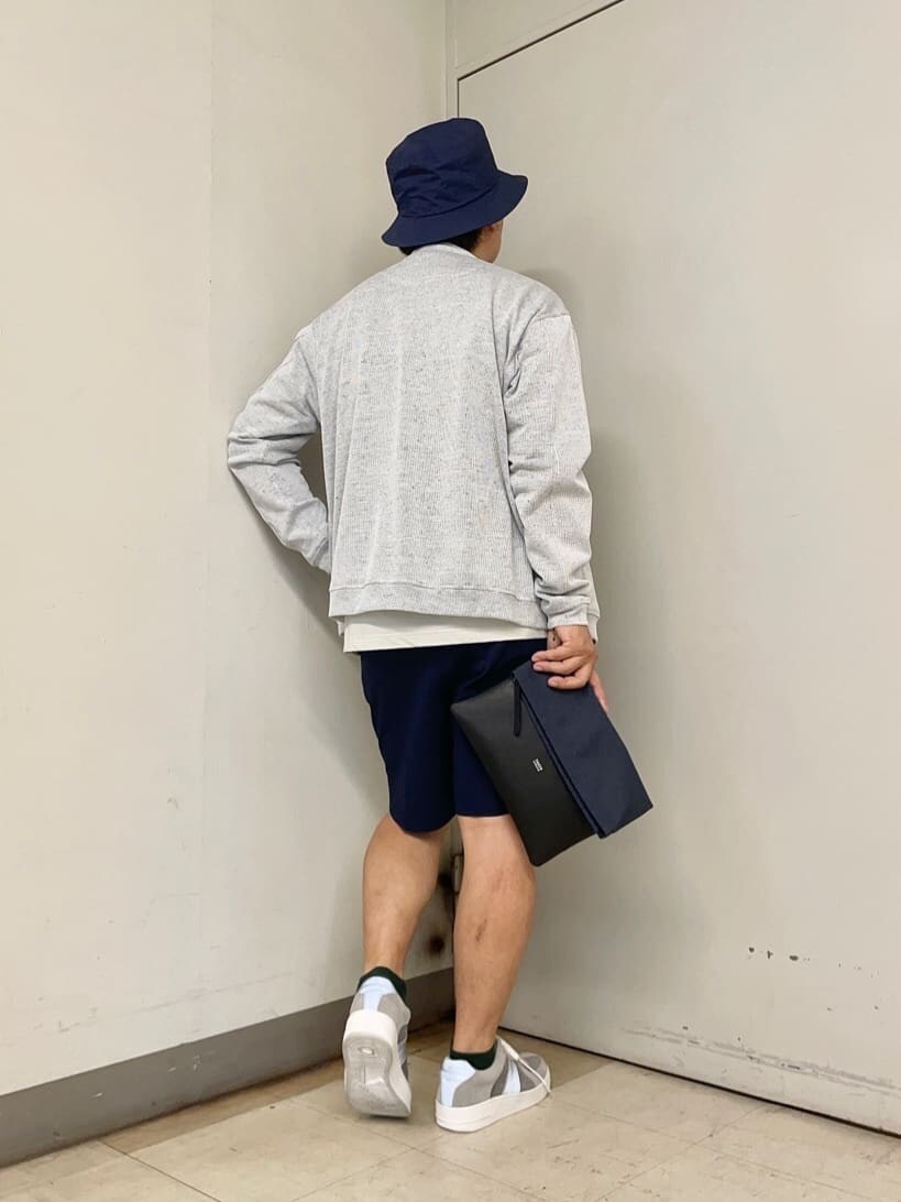 ブルー系のクラッチバッグ、ブルー系のハットを着用したメンズの夏コーディネートの3枚目の写真