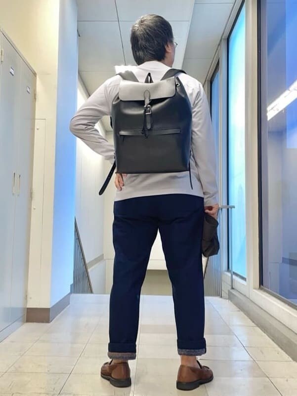 ブルー系のデニムパンツ、ブラック系のバックパック/リュックを着用したメンズの秋コーディネートの3枚目の写真