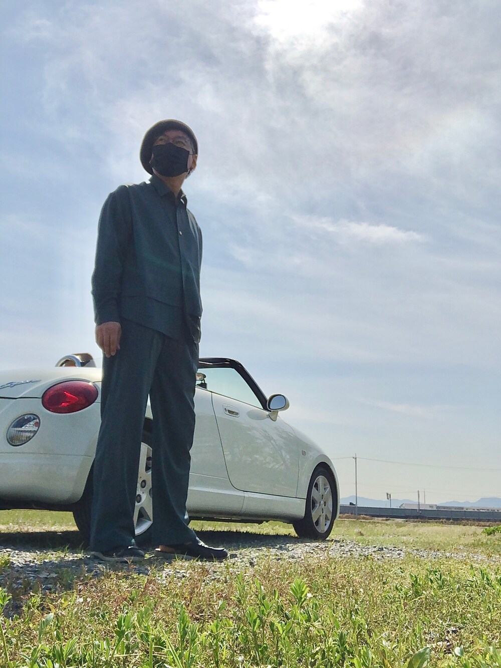 グリーン系のセットアップ、ブラック系のローファー、ブルー系の帽子を着用したメンズの春コーディネートの2枚目の写真