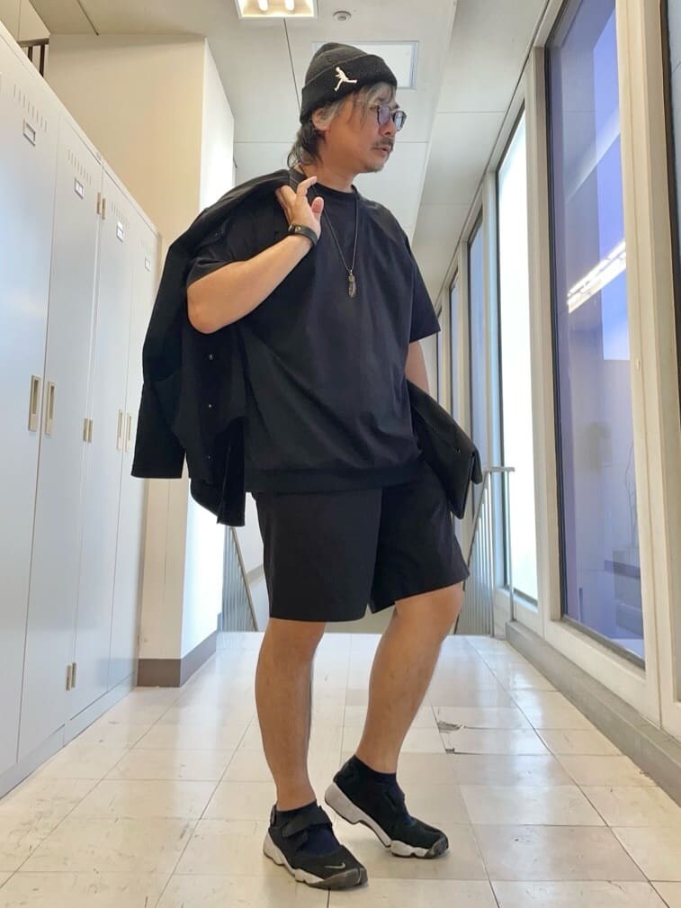 ブラック系のTシャツ/カットソー、ブラック系のクラッチバッグ、ブラック系のニットキャップ/ビーニーを着用したメンズの夏コーディネートの7枚目の写真