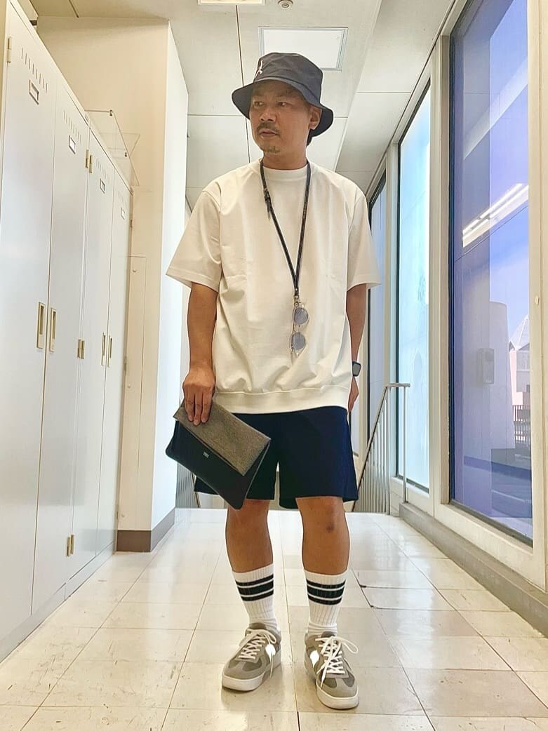 ブルー系のその他パンツ、グレー系のクラッチバッグ、ブルー系のハットを着用したメンズの夏コーディネートの5枚目の写真