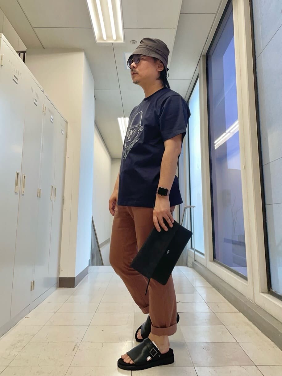 ブラック系のクラッチバッグ、ブルー系のTシャツ/カットソーを着用したメンズの春コーディネートの2枚目の写真