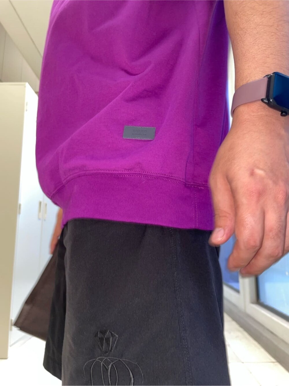 パープル系のTシャツ/カットソー、ブラウン系のクラッチバッグ、ブラック系のニットキャップ/ビーニーを着用したメンズの夏コーディネートの5枚目の写真