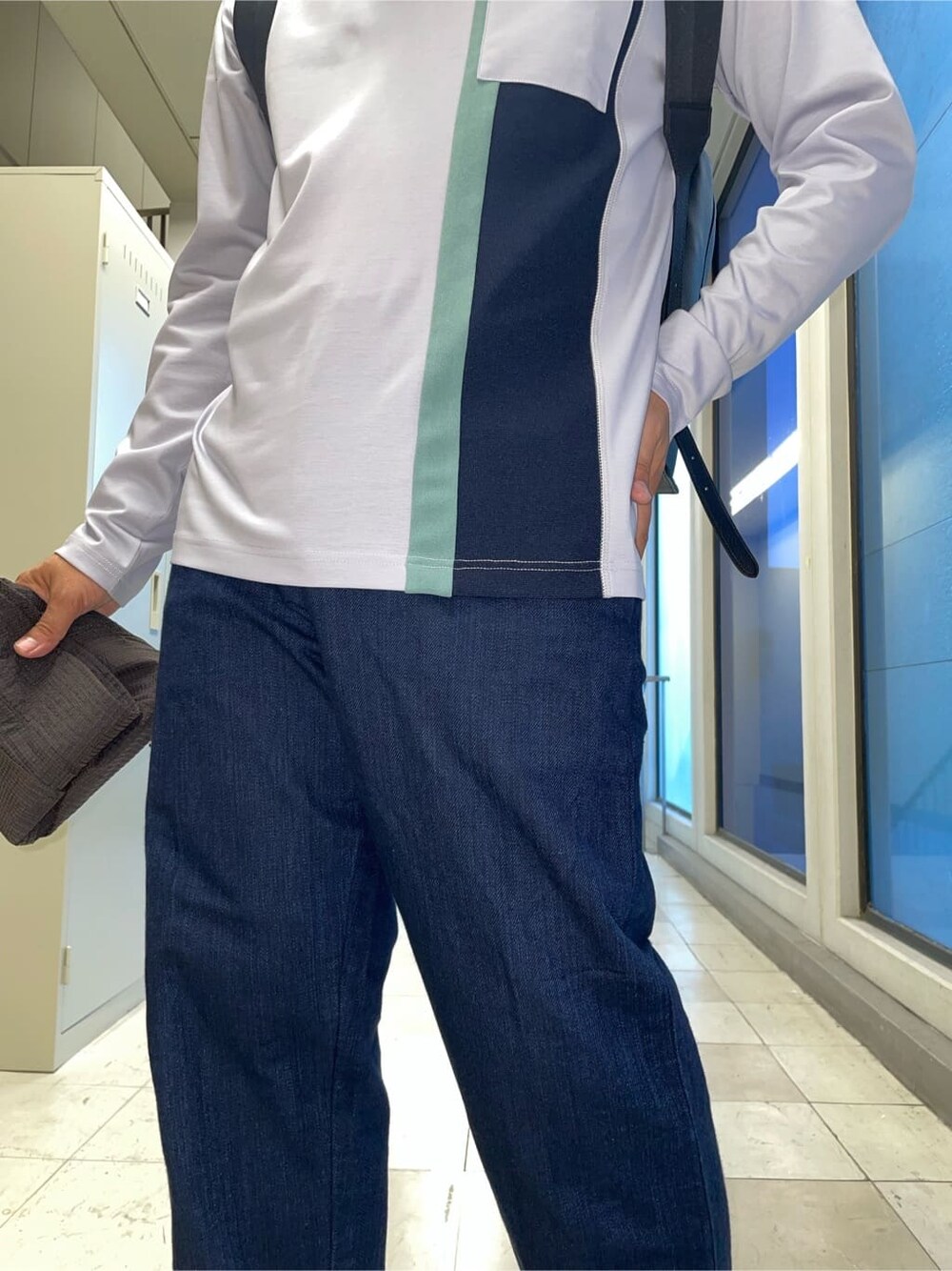 ブルー系のデニムパンツ、ブラック系のバックパック/リュックを着用したメンズの秋コーディネートの4枚目の写真