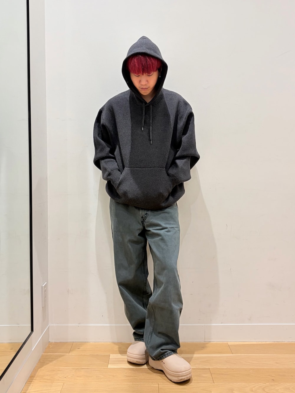 グレー系のパーカー、ブルー系のデニムパンツを着用したメンズの秋コーディネートの2枚目の写真