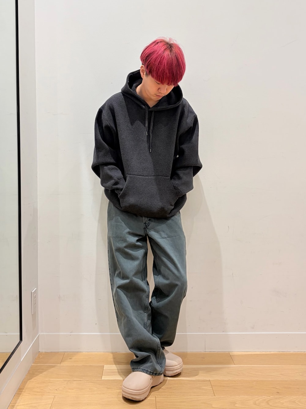 グレー系のパーカー、ブルー系のデニムパンツを着用したメンズの秋コーディネートの3枚目の写真