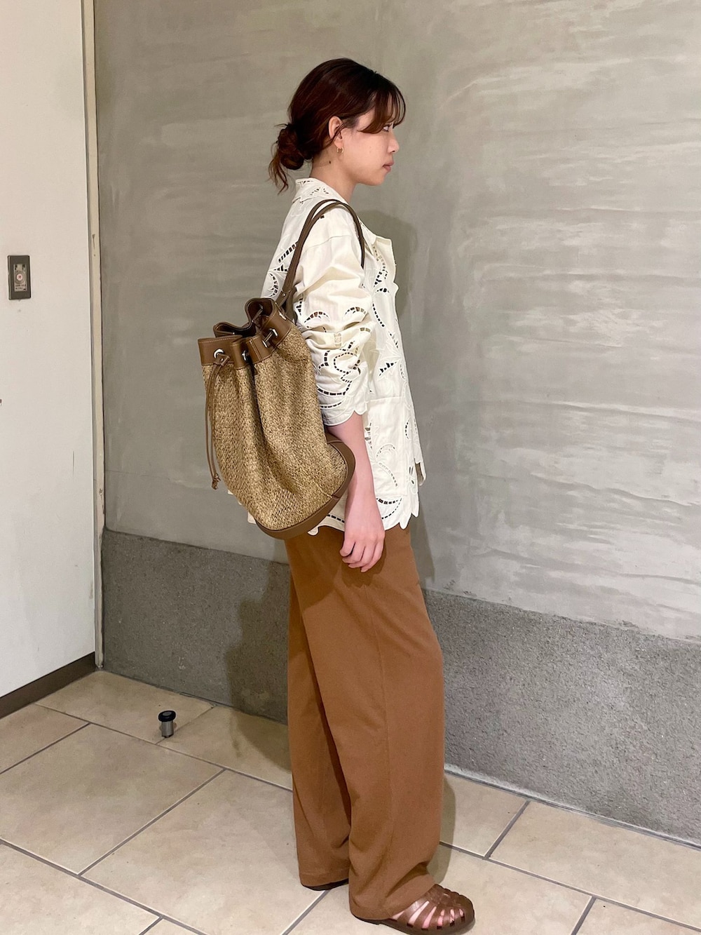 イエロー系のスウェットパンツ、ホワイト系のシャツ/ブラウス、ベージュ系のバックパック/リュックを着用したレディースの夏コーディネートの2枚目の写真