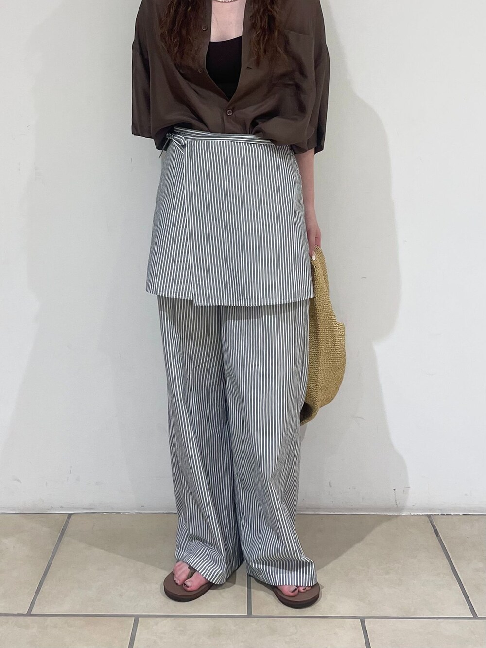 ホワイト系のその他パンツ、ブラウン系のシャツ/ブラウス、ホワイト系のかごバッグを着用したレディースの夏コーディネートの5枚目の写真