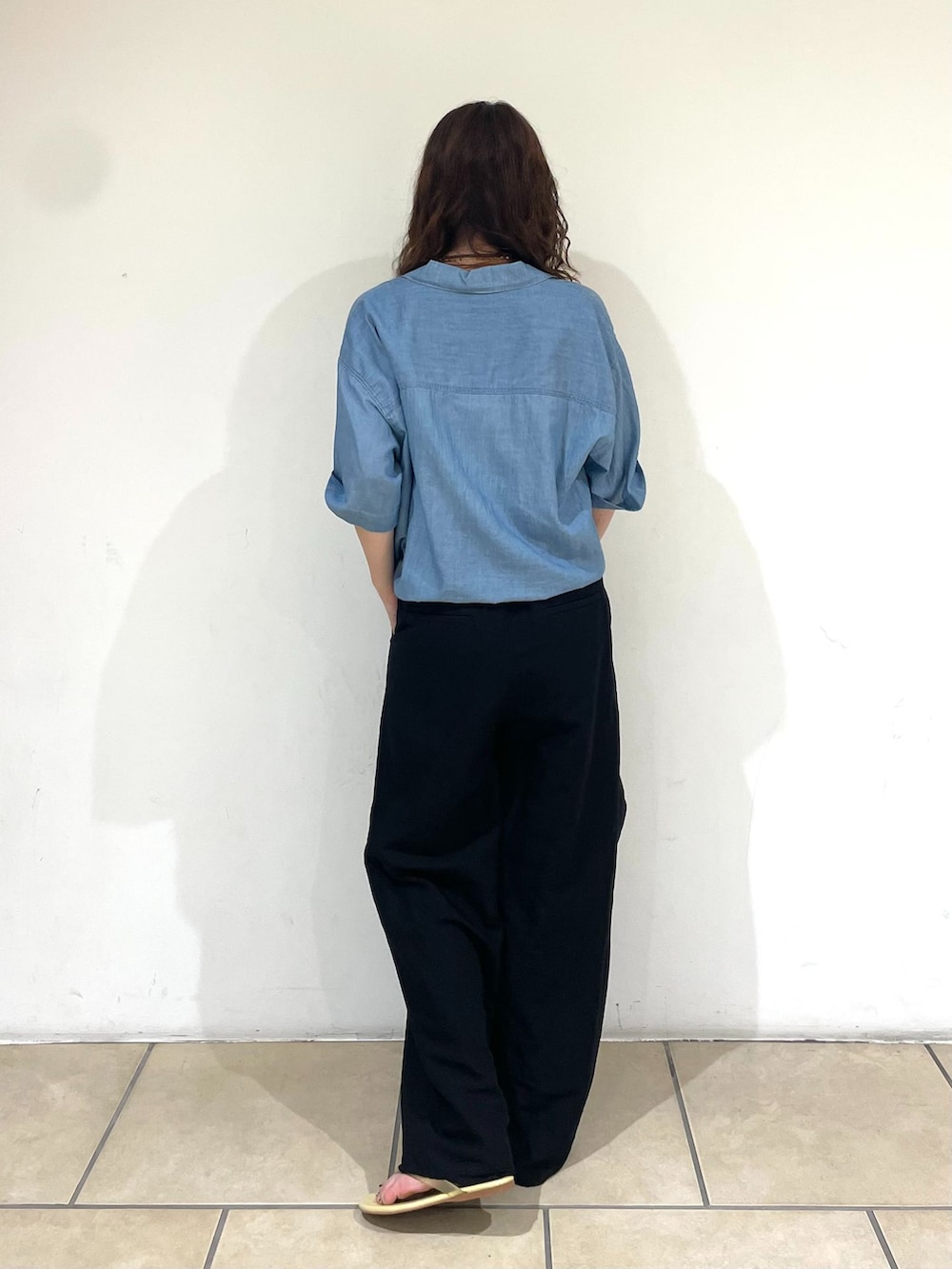 ブラック系のスラックス、ブルー系のシャツ/ブラウス、ブラック系のハンドバッグを着用したレディースの春コーディネートの3枚目の写真