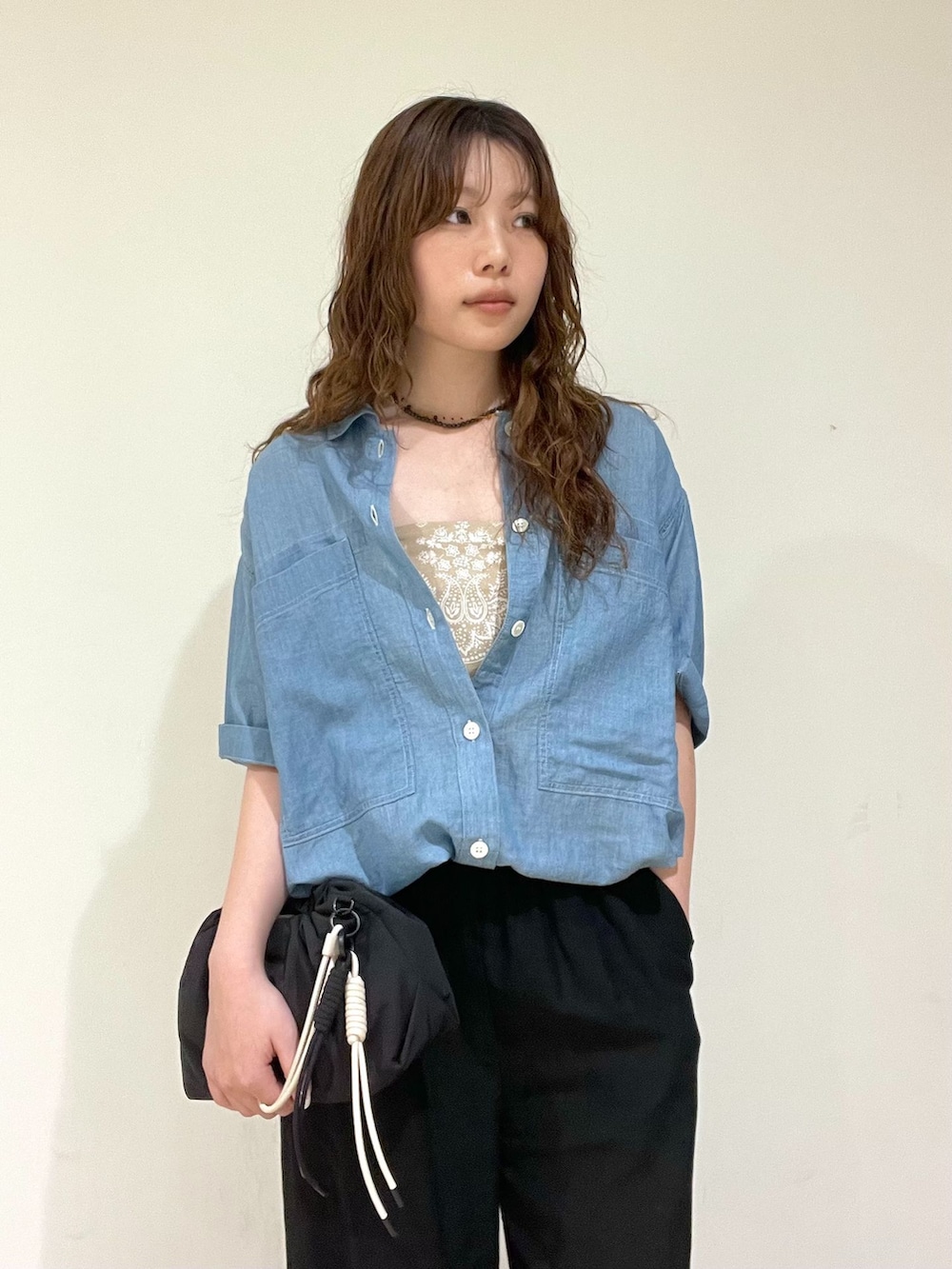 ブラック系のスラックス、ブルー系のシャツ/ブラウス、ブラック系のハンドバッグを着用したレディースの春コーディネートの4枚目の写真