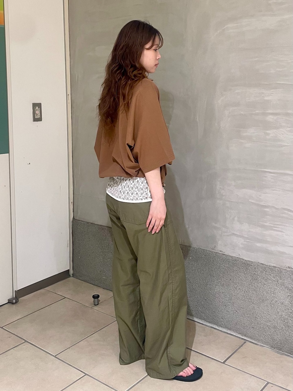 グリーン系のカーゴパンツ、イエロー系のTシャツ/カットソー、ブラック系のサンダルを着用したレディースの夏コーディネートの2枚目の写真