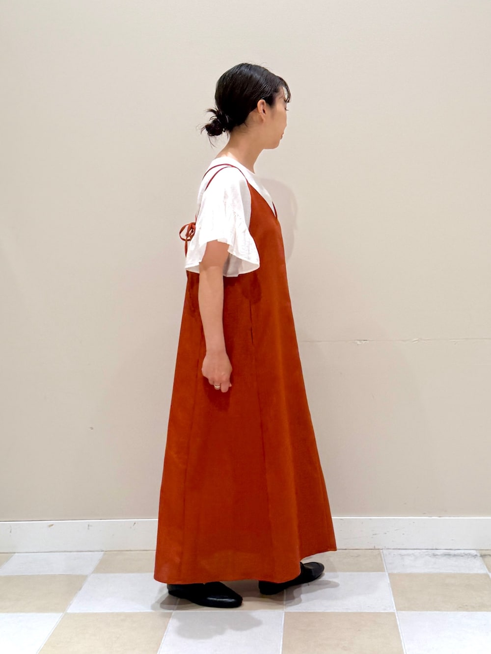 オレンジ系のワンピース、ホワイト系のシャツ/ブラウス、ホワイト系のハンドバッグを着用したレディースの春コーディネートの4枚目の写真