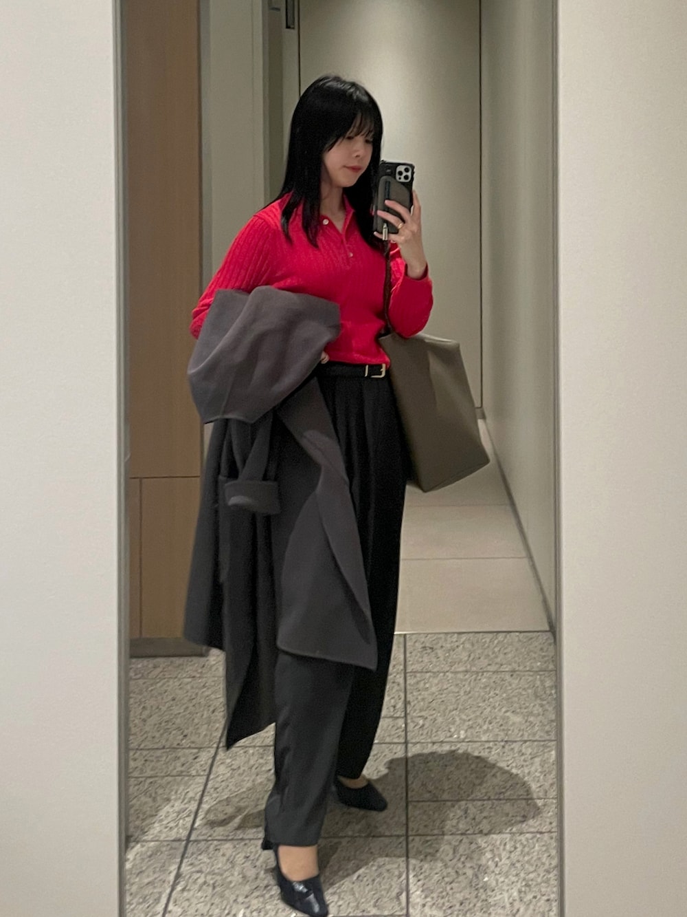 グレー系のノーカラーコート、ブラウン系のトートバッグ、グレー系のスラックスを着用したレディースの春コーディネートの2枚目の写真