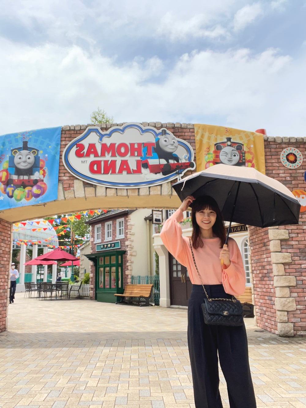 ピンク系のシャツ/ブラウス、ブラック系のショルダーバッグ、ブルー系のスラックスを着用したレディースの夏コーディネートの2枚目の写真