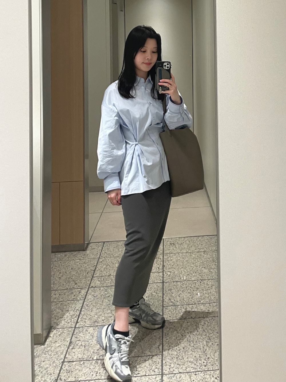 ブルー系のシャツ/ブラウス、ホワイト系のマウンテンパーカー、グレー系のスカートを着用したレディースの春コーディネートの2枚目の写真