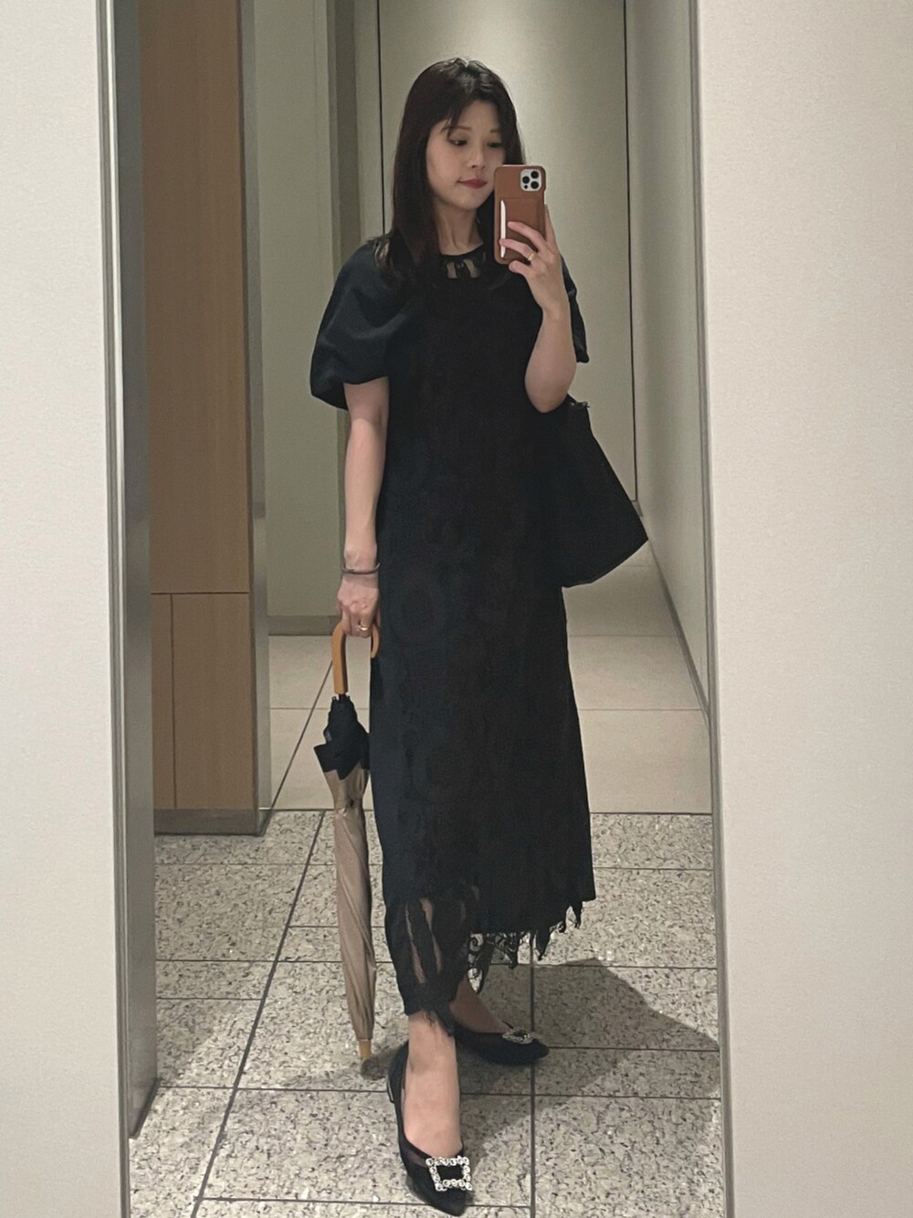 ブラック系のワンピース、ブラック系のパンプス、ブラック系のショルダーバッグを着用したレディースの夏コーディネートの2枚目の写真