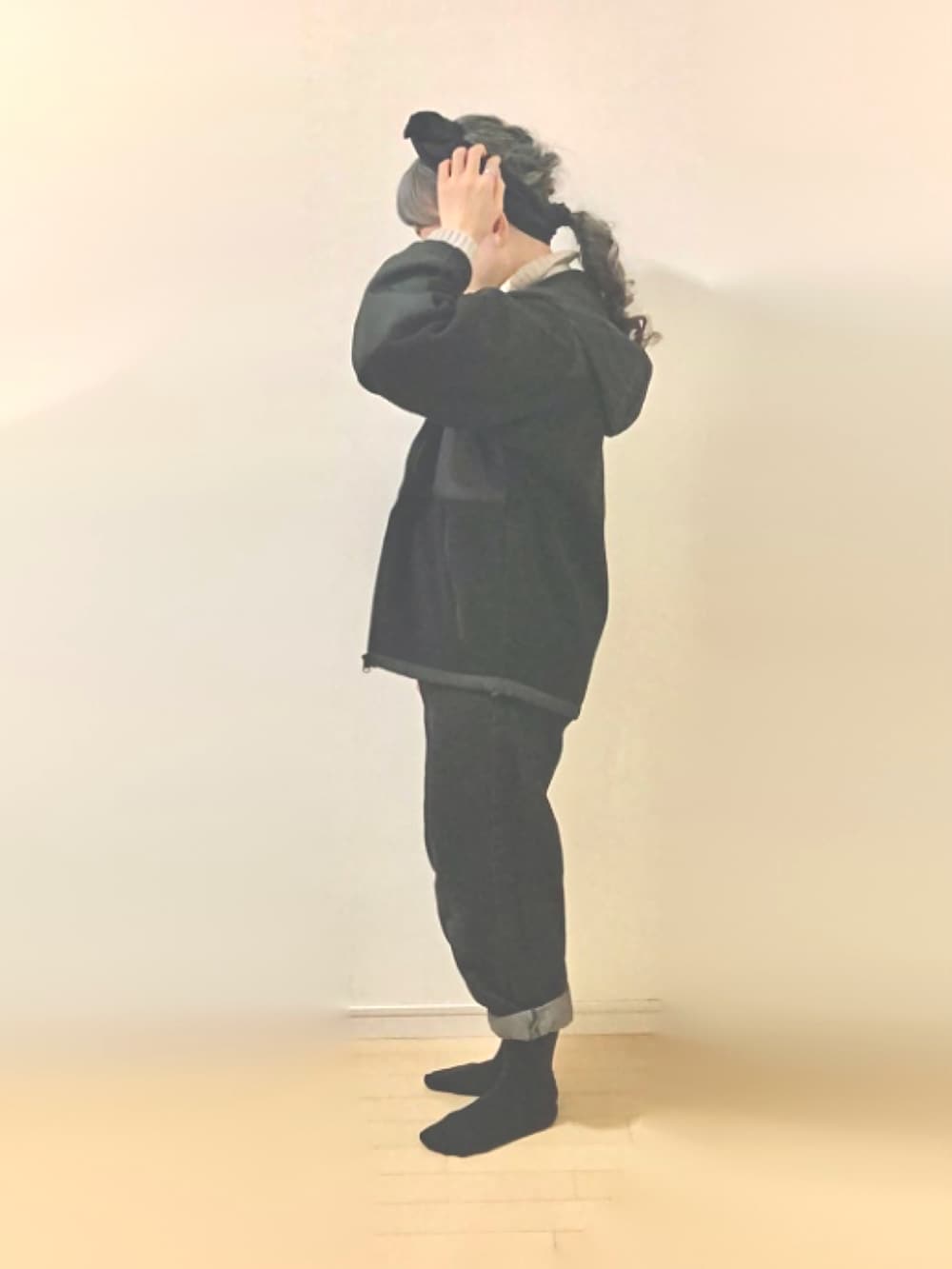 ブラック系のデニムパンツ、ブラック系のブルゾン、ベージュ系のニット/セーターを着用したレディースの秋コーディネートの2枚目の写真