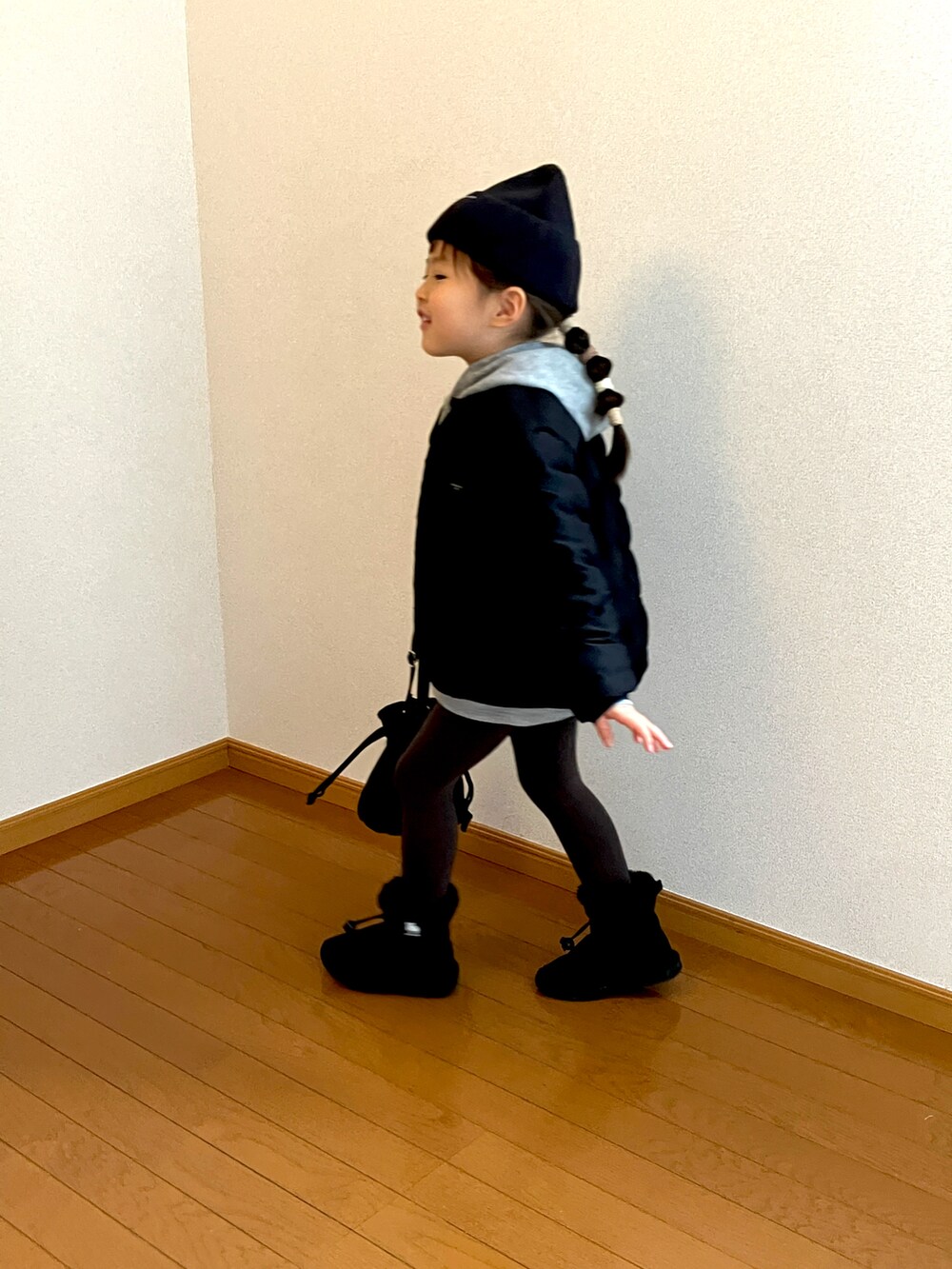 ブラック系のトートバッグ、グレー系のパーカーを着用したキッズの冬コーディネートの2枚目の写真