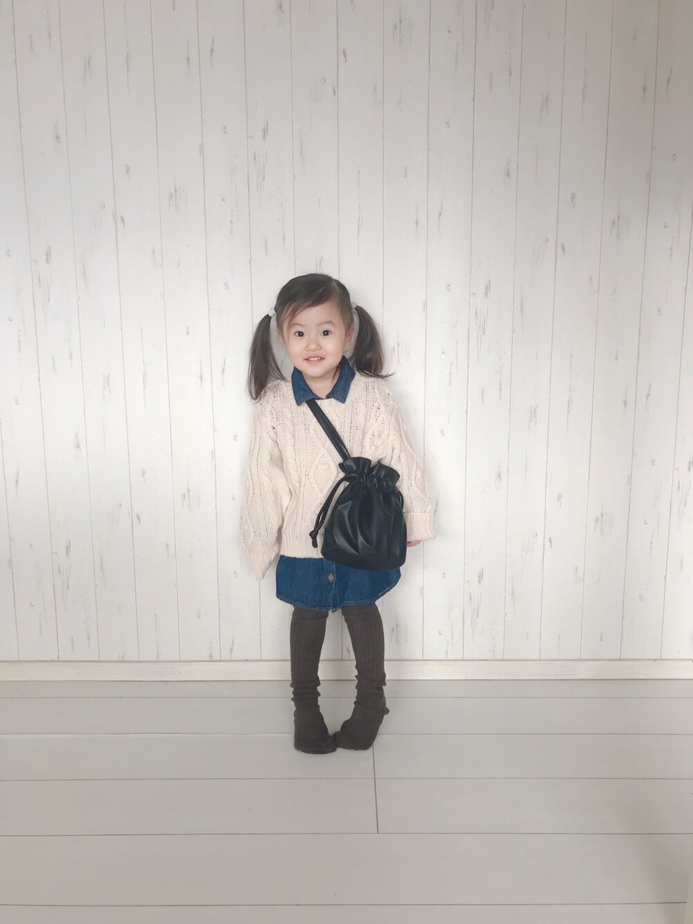 ホワイト系のニット/セーター、ブラック系のトートバッグを着用したキッズの冬コーディネートの2枚目の写真