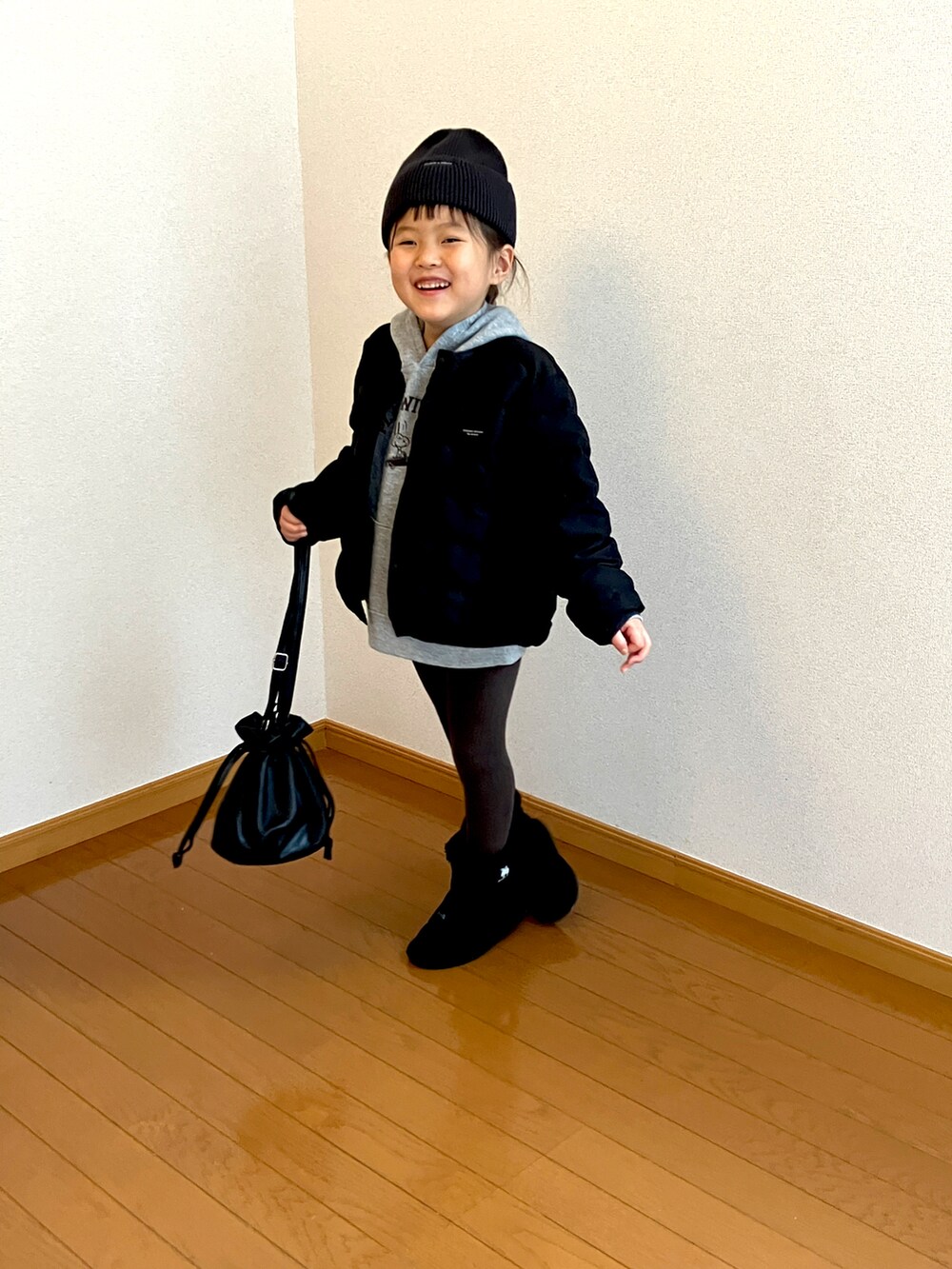 ブラック系のトートバッグ、グレー系のパーカーを着用したキッズの冬コーディネートの3枚目の写真