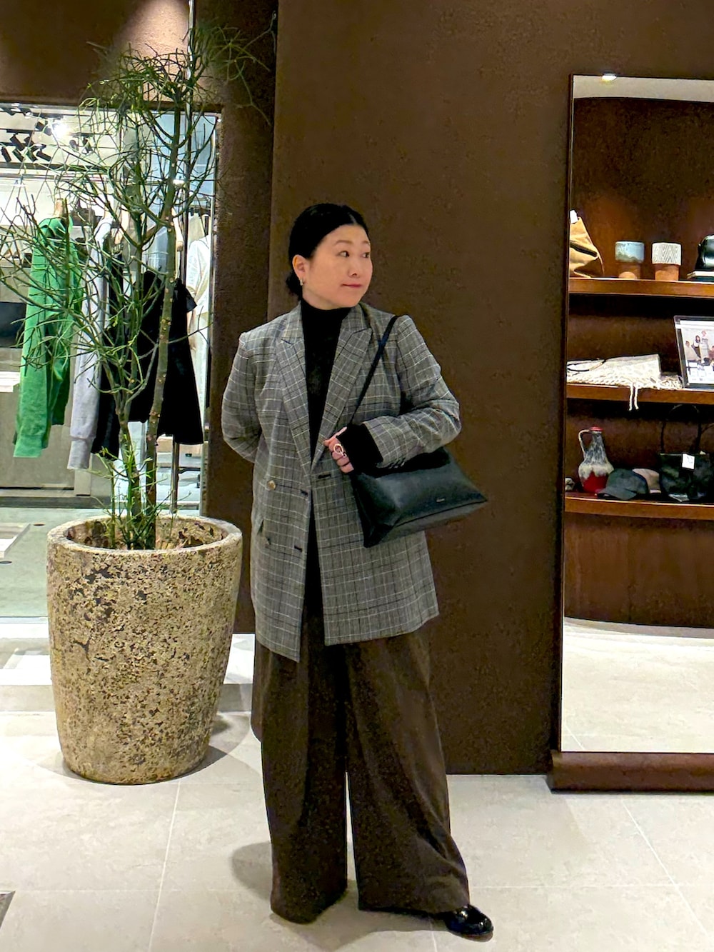 グレー系のテーラードジャケット、ブラウン系のその他パンツ、ブラック系のニット/セーターを着用したレディースの秋コーディネートの2枚目の写真