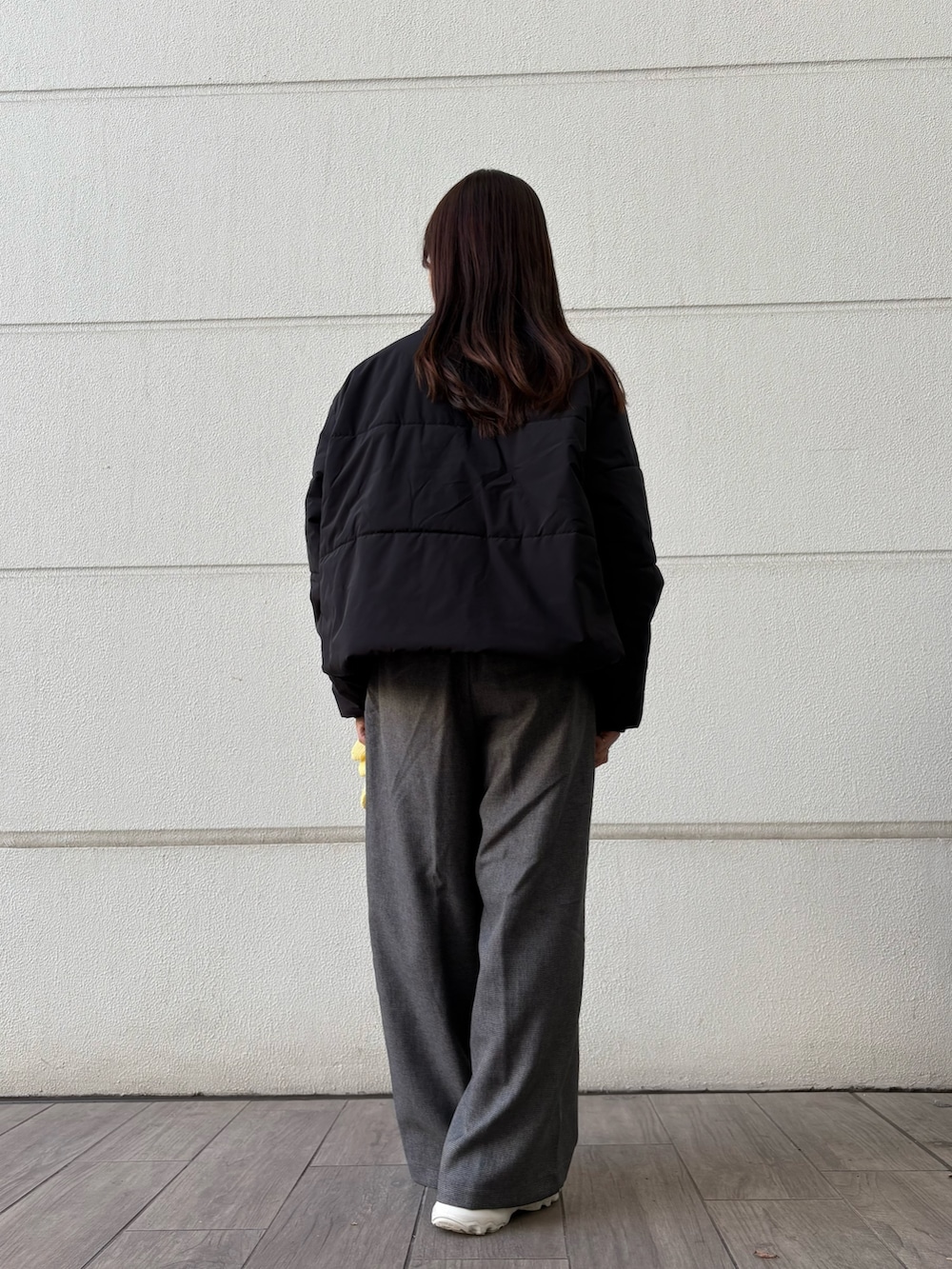 ホワイト系のニット/セーター、グレー系のその他パンツ、ブラック系のダウンジャケット/コートを着用したレディースの冬コーディネートの5枚目の写真