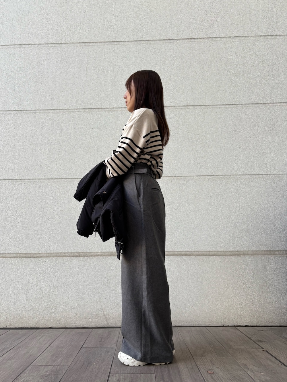 ホワイト系のニット/セーター、グレー系のその他パンツ、ブラック系のダウンジャケット/コートを着用したレディースの冬コーディネートの2枚目の写真