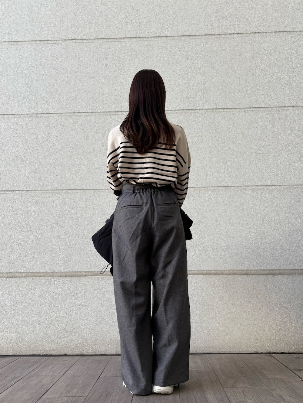 ホワイト系のニット/セーター、グレー系のその他パンツ、ブラック系のダウンジャケット/コートを着用したレディースの冬コーディネートの3枚目の写真