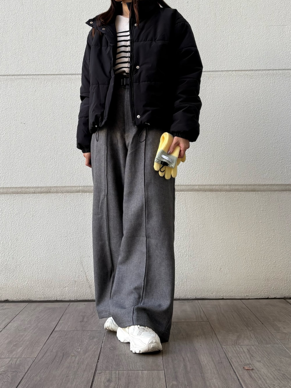 ホワイト系のニット/セーター、グレー系のその他パンツ、ブラック系のダウンジャケット/コートを着用したレディースの冬コーディネートの4枚目の写真