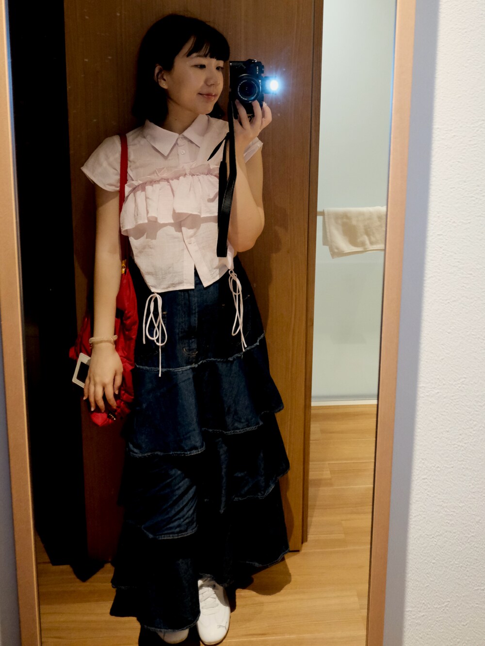 ピンク系のシャツ/ブラウス、ブルー系のデニムスカート、ホワイト系のその他シューズを着用したレディースの夏コーディネートの4枚目の写真