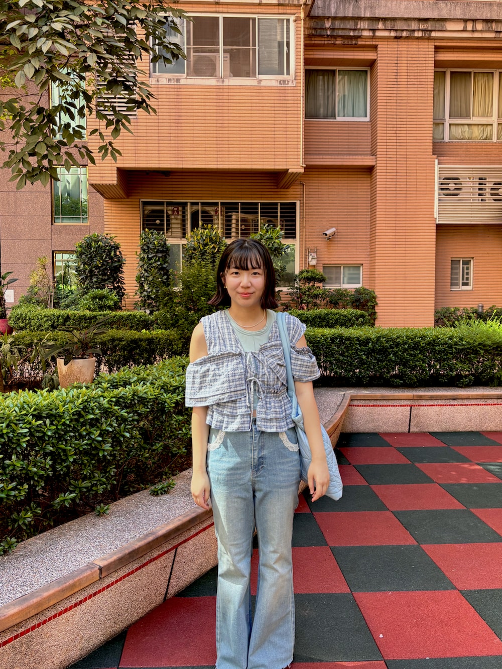 ブルー系のデニムパンツ、ブルー系のシャツ/ブラウス、ブルー系のショルダーバッグを着用したレディースの夏コーディネートの3枚目の写真