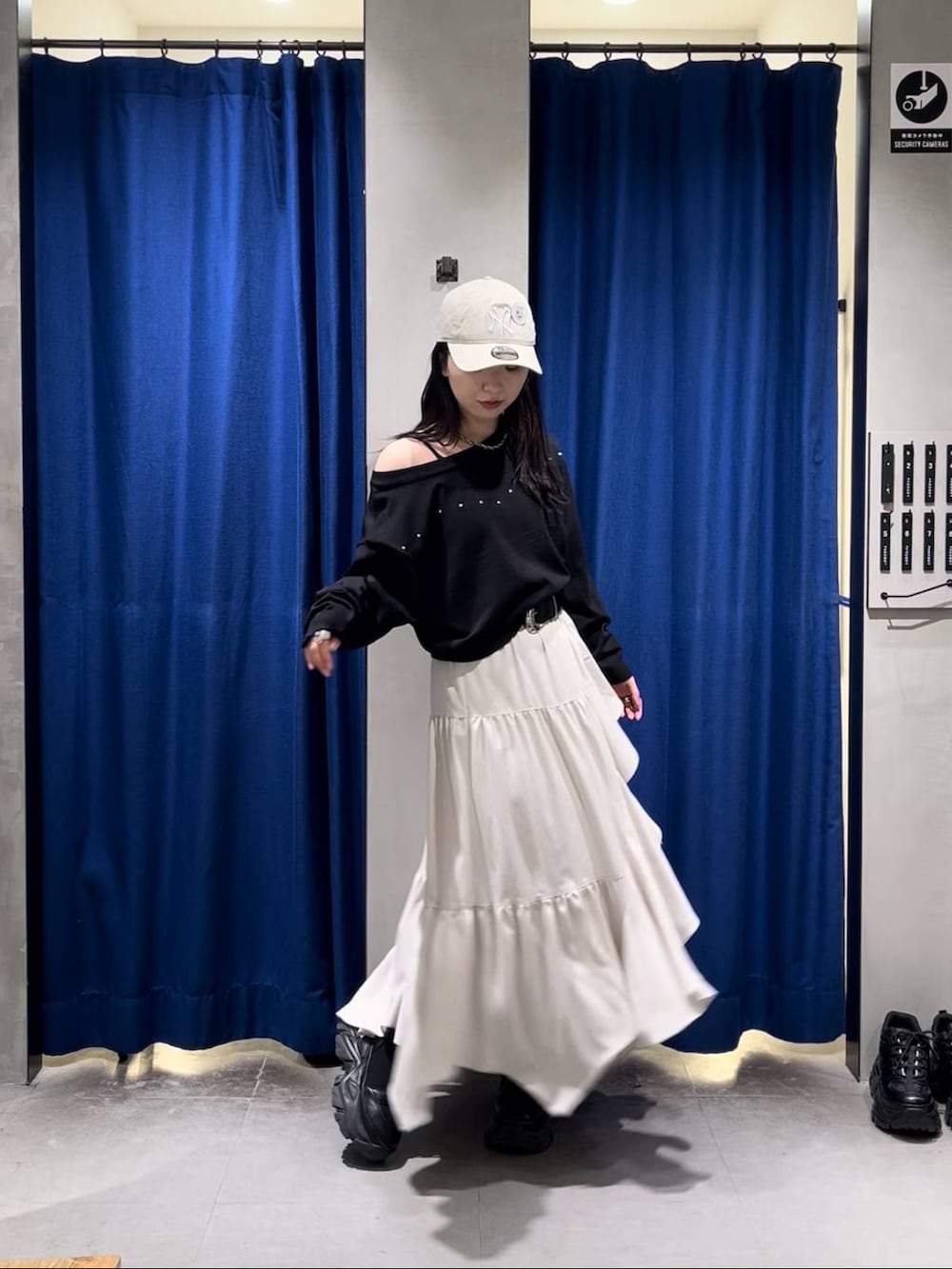 ブラック系のブーツ、ブラック系のキャミソール、ベージュ系のスカートを着用したレディースの春コーディネートの2枚目の写真