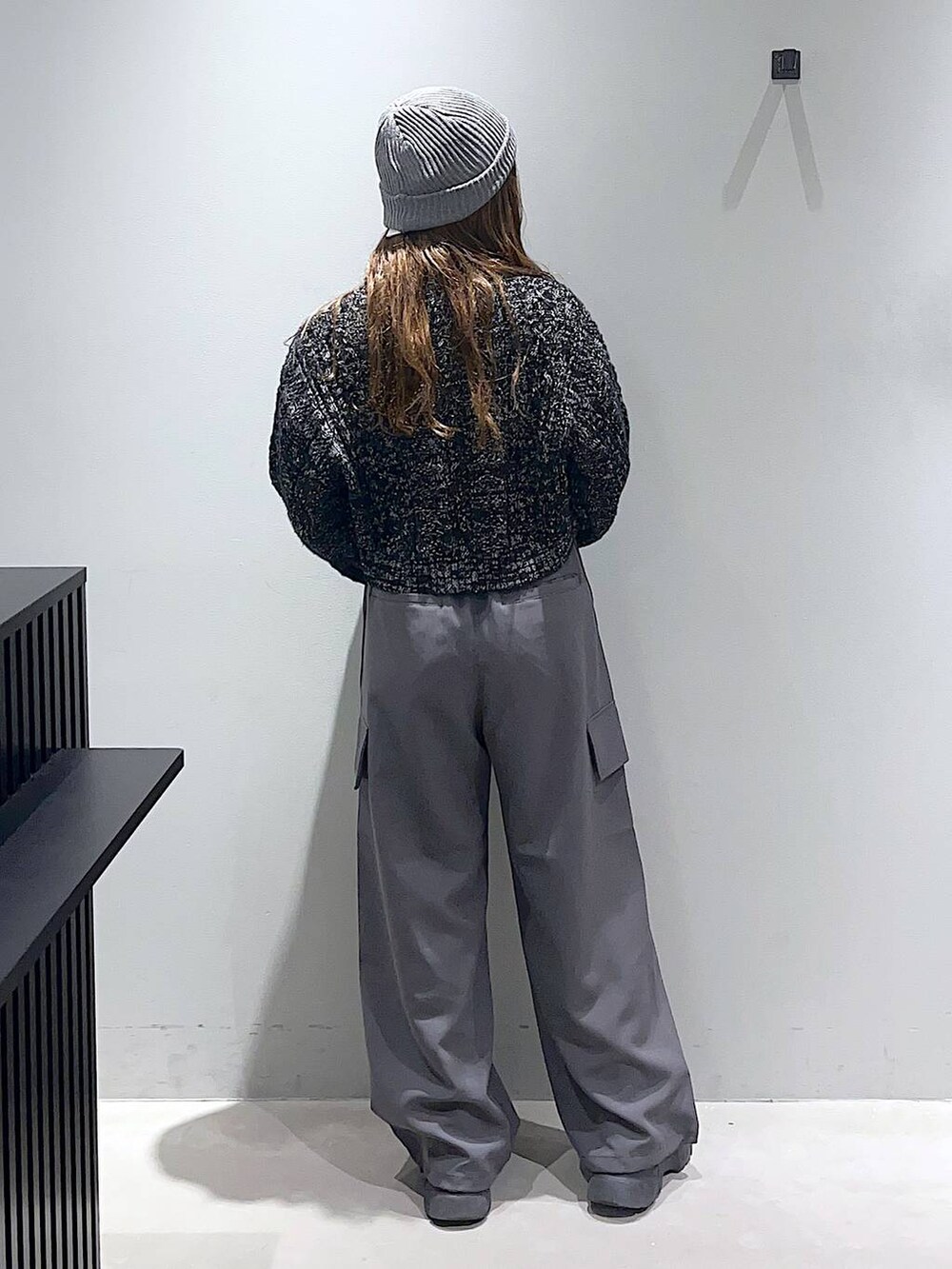 グレー系のその他パンツ、ブラック系のブーツ、ブラック系のニット/セーターを着用したレディースの冬コーディネートの2枚目の写真