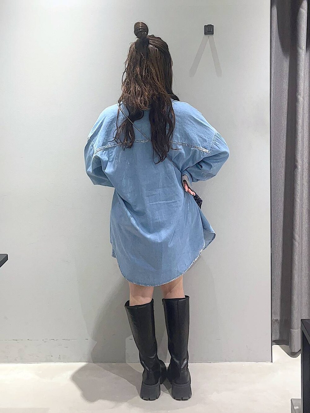 グレー系のTシャツ/カットソー、ブラック系のブーツ、ブラック系のショルダーバッグを着用したレディースの冬コーディネートの2枚目の写真