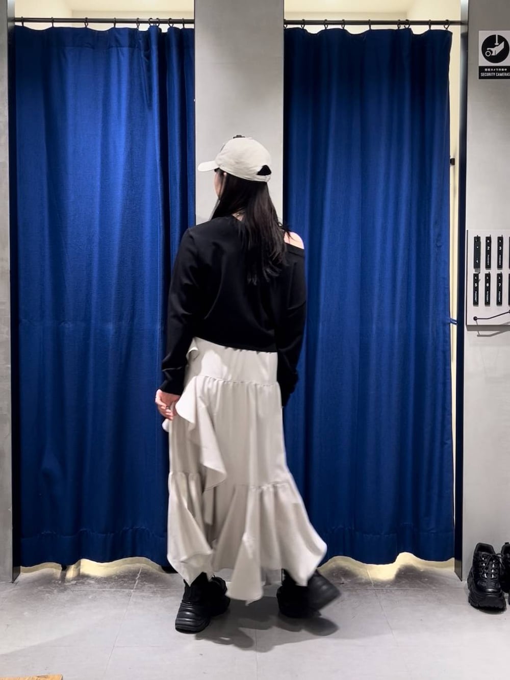 ブラック系のブーツ、ブラック系のキャミソール、ベージュ系のスカートを着用したレディースの春コーディネートの5枚目の写真