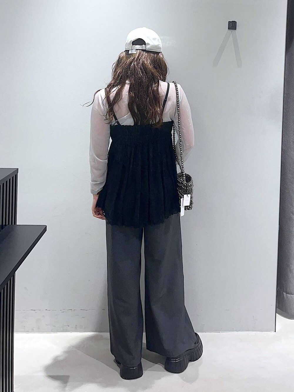 シルバー系のTシャツ/カットソー、グレー系のスラックス、ブラック系のローファーを着用したレディースの冬コーディネートの2枚目の写真