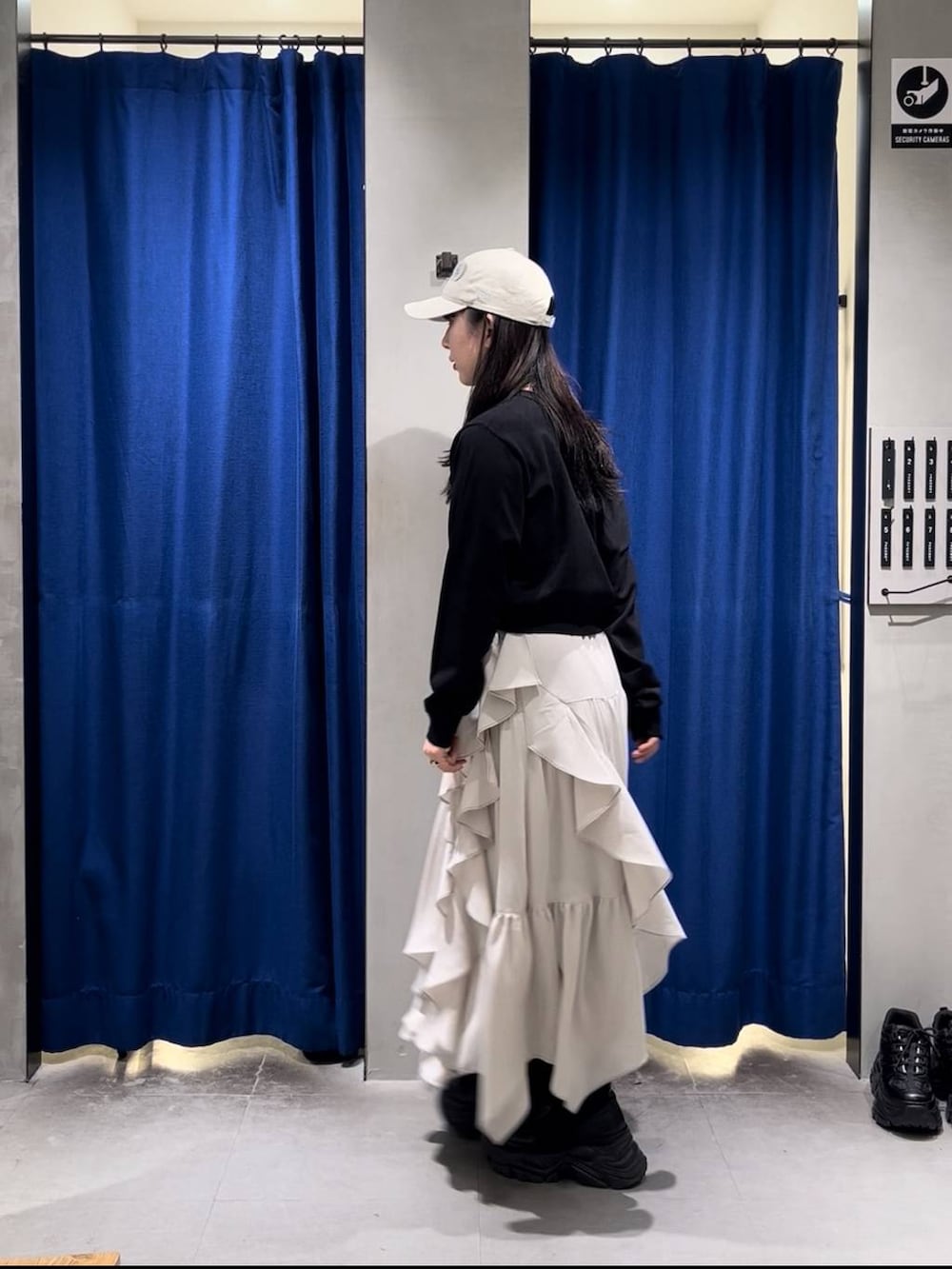 ブラック系のブーツ、ブラック系のキャミソール、ベージュ系のスカートを着用したレディースの春コーディネートの3枚目の写真