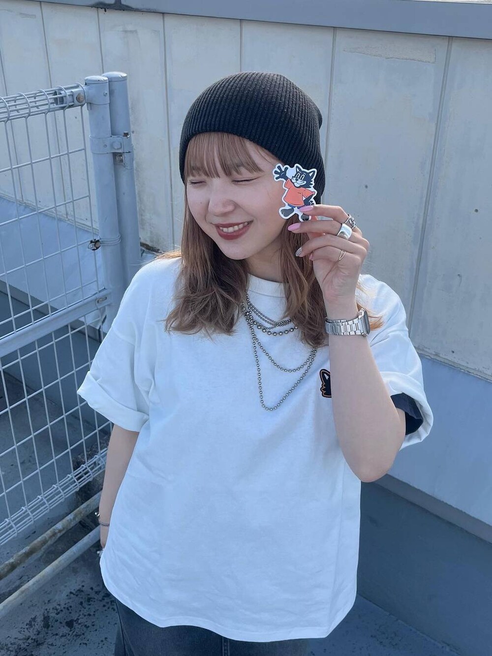 ブラック系のブーツ、ブラック系のデニムスカート、ホワイト系のTシャツ/カットソーを着用したレディースの春コーディネートの3枚目の写真