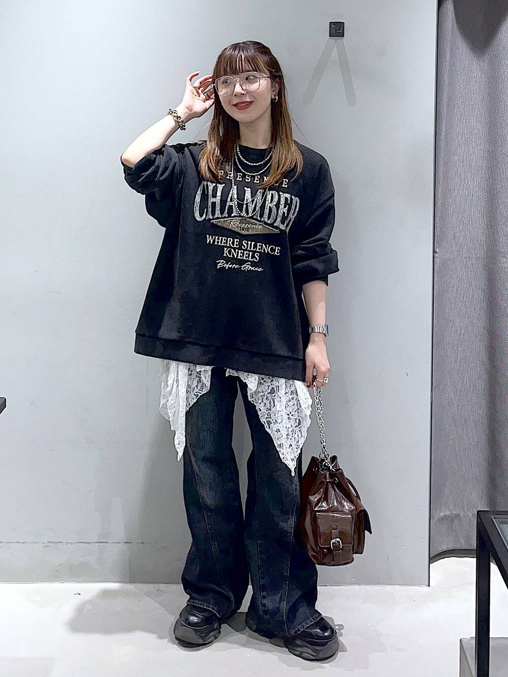 ブラック系のブーツ、ブルー系のデニムパンツ、ブラウン系のショルダーバッグを着用したレディースの秋コーディネートの5枚目の写真