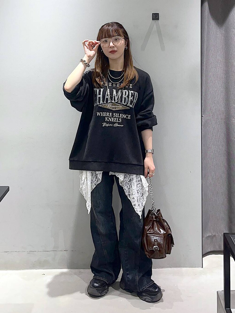 ブラック系のブーツ、ブルー系のデニムパンツ、ブラウン系のショルダーバッグを着用したレディースの秋コーディネートの4枚目の写真