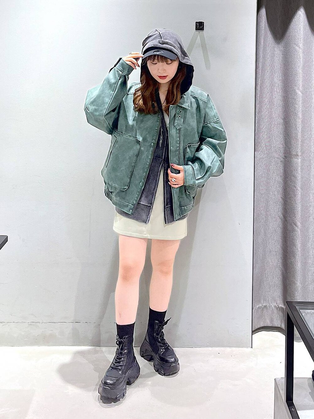 ブラック系のブーツ、ブラック系のボストンバッグ、グレー系のパーカーを着用したレディースの秋コーディネートの5枚目の写真